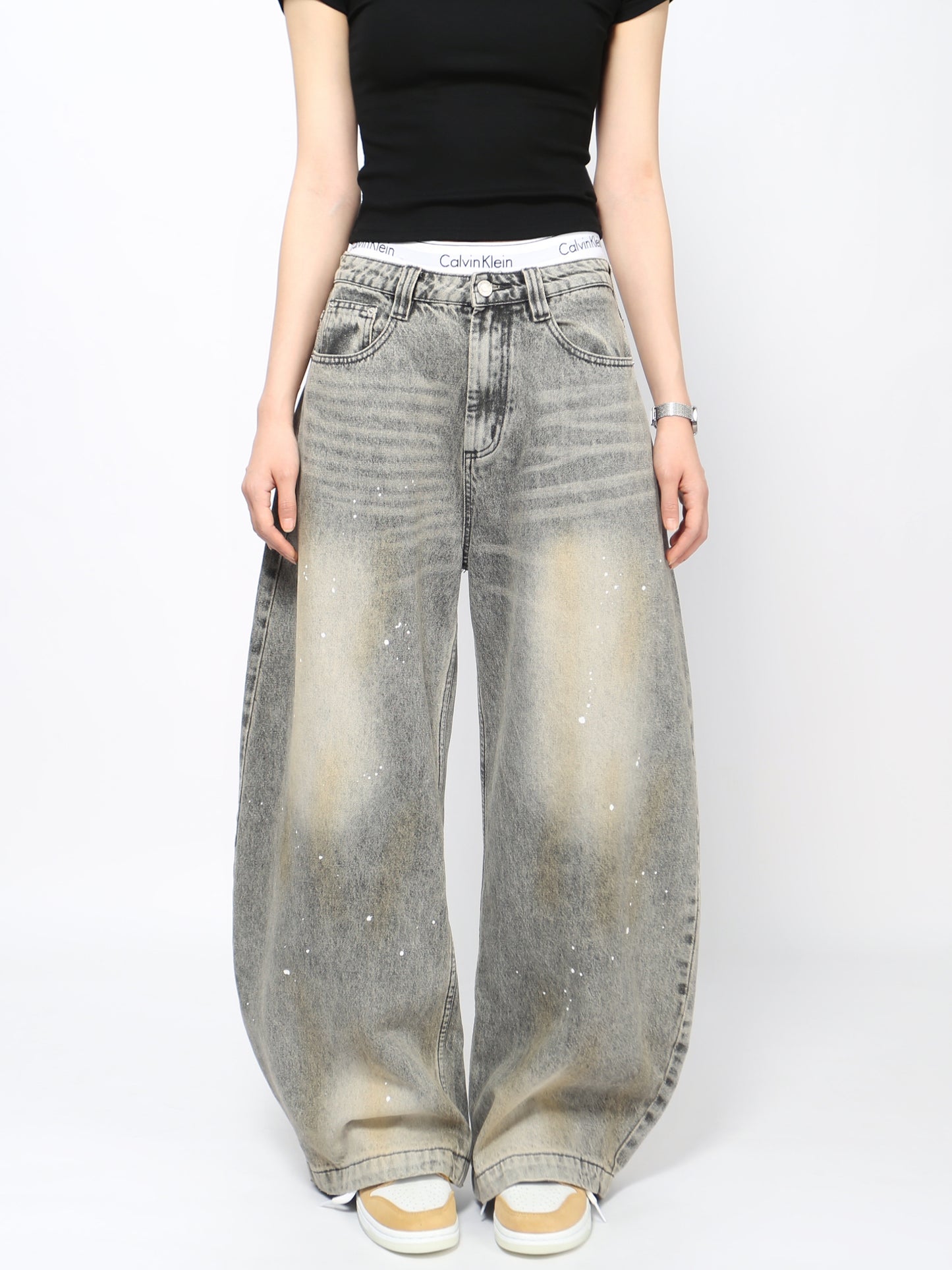 Jeans grises lavados con diseño curvo y salpicaduras, estilo urbano vintage