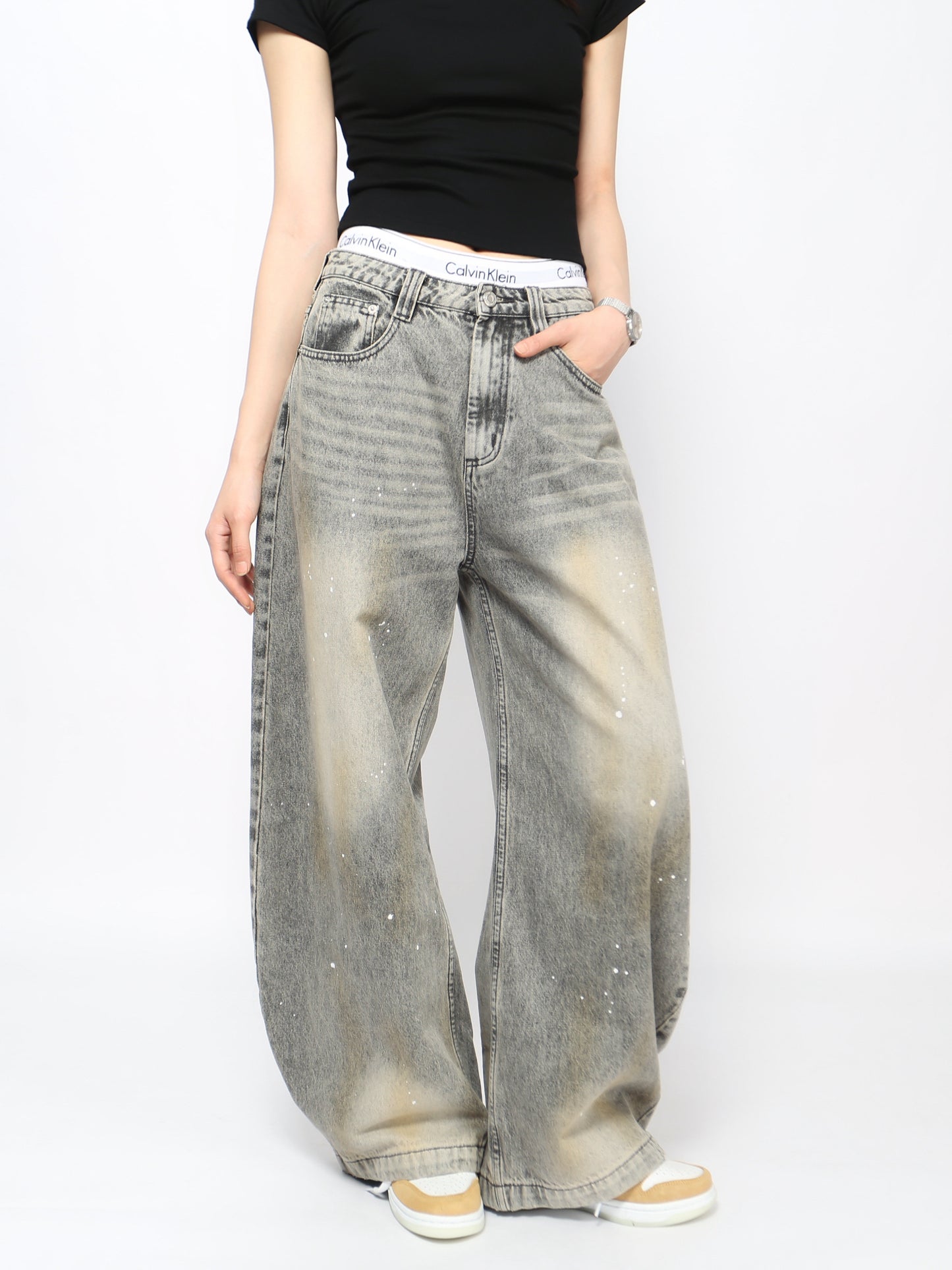 Jeans grises lavados con diseño curvo y salpicaduras, estilo urbano vintage